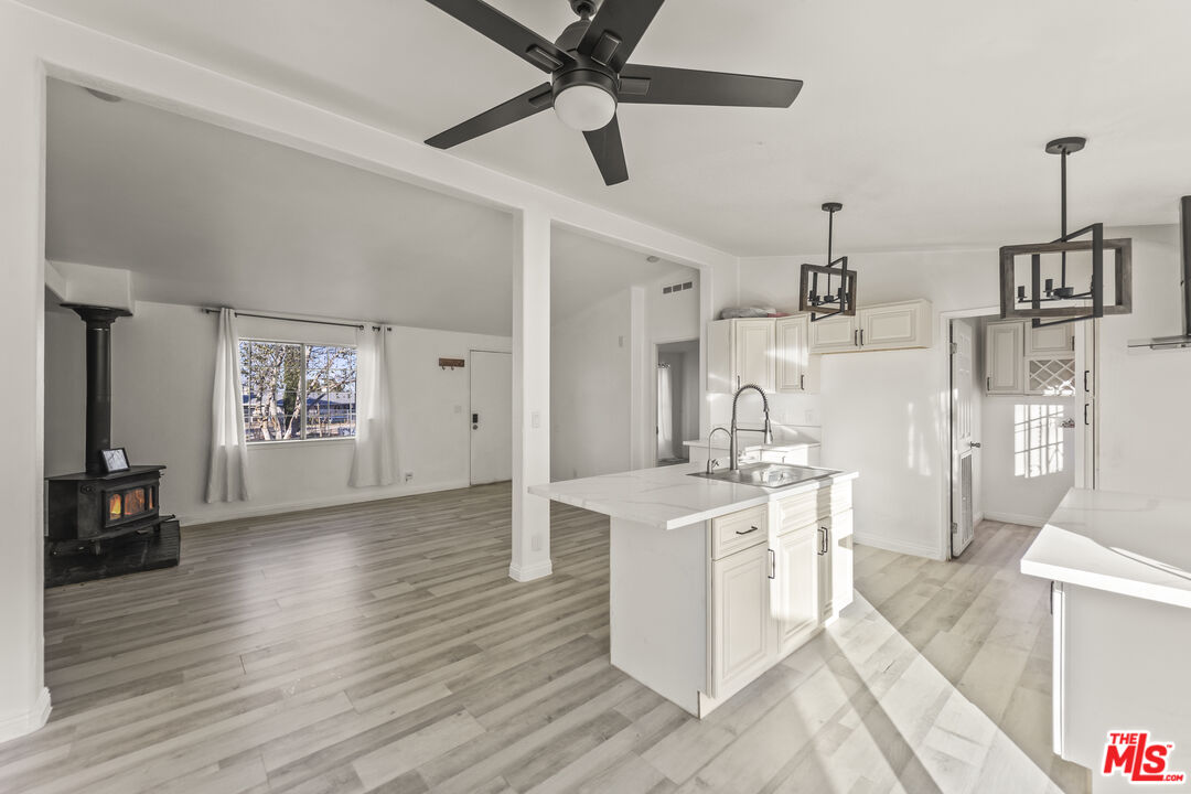 6677 Maricopa Road Phelan, CA 92371 - Photo 4 of 38 a open kitchen with cabinets a stove and a wooden floor