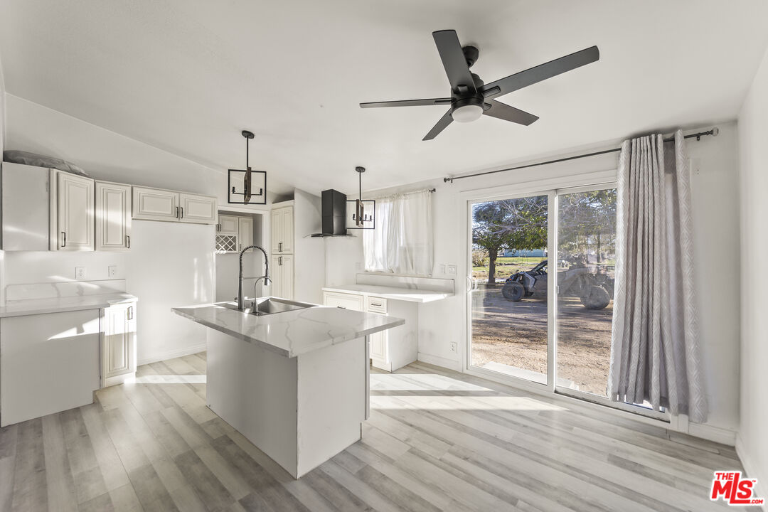 6677 Maricopa Road Phelan, CA 92371 - Photo 7 of 38 a kitchen with stainless steel appliances granite countertop a stove a refrigerator a sink and a wooden floors