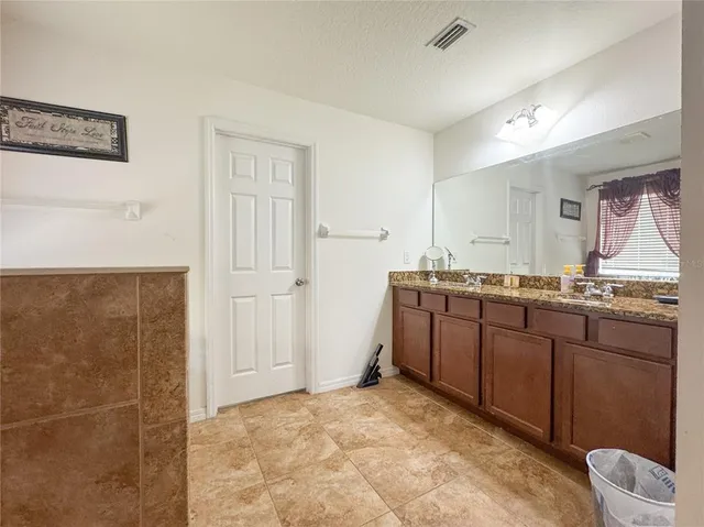 a spacious bathroom with a granite countertop sink a mirror and a