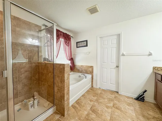 a bathroom with a tub shower and mirror