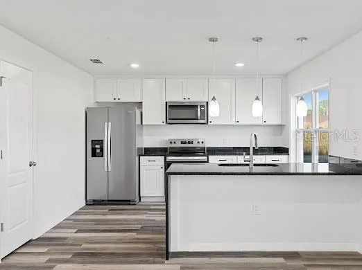 a kitchen with stainless steel appliances granite countertop a stove a sink and a refrigerator