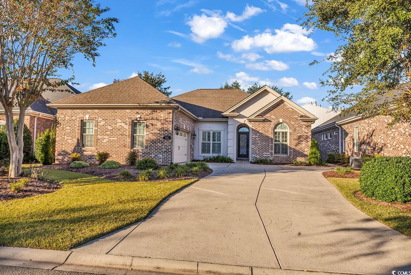 956 Corrado Street Myrtle Beach, SC 29572 - Photo 1 of 38 Ranch-style house featuring brick siding, concrete driveway, a shingled roof, and a front yard