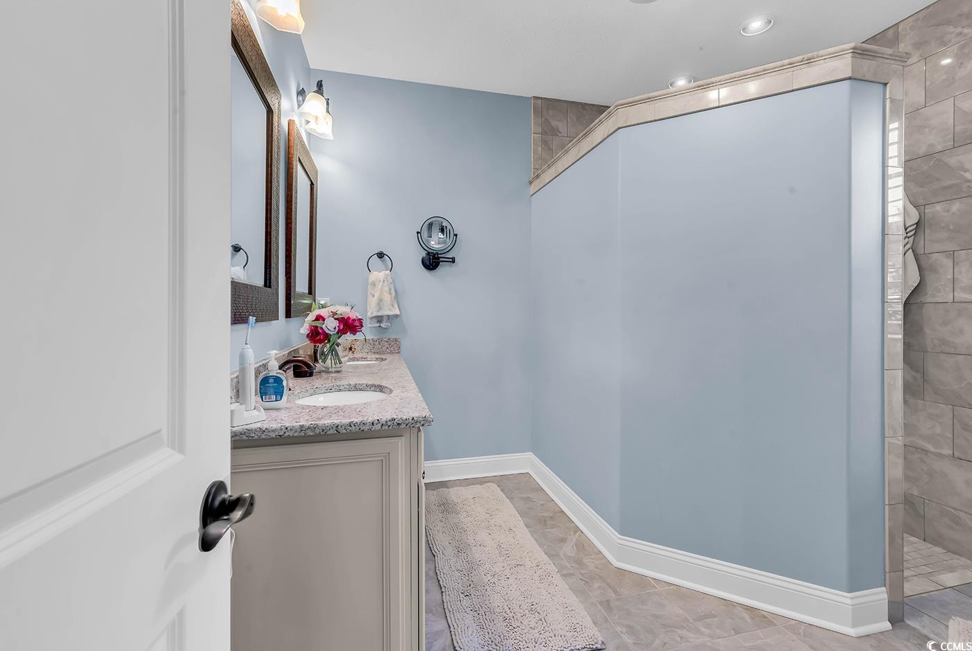 956 Corrado Street Myrtle Beach, SC 29572 - Photo 20 of 38 Bathroom with double vanity, a walk in shower, and light tile patterned flooring