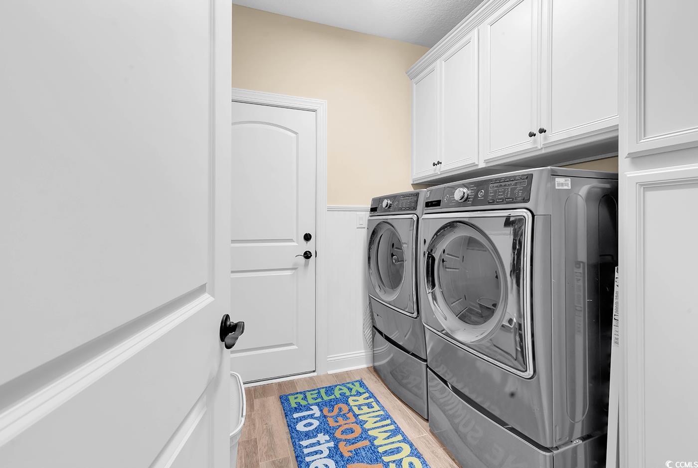 956 Corrado Street Myrtle Beach, SC 29572 - Photo 28 of 38 Washroom featuring washing machine and dryer, light wood finished floors, and cabinet space