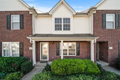 a view of a brick house with large windows