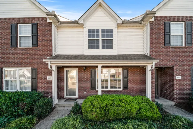 a view of a brick house with large windows