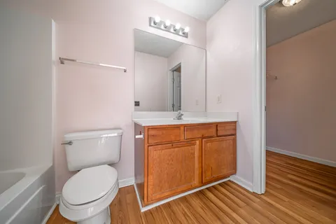 a bathroom with a granite countertop toilet sink and mirror
