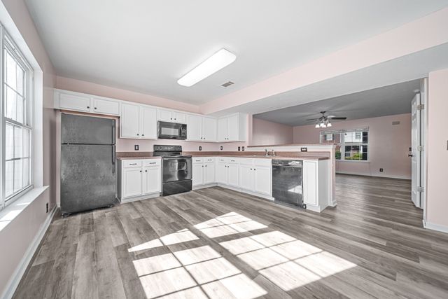 a kitchen with stainless steel appliances granite countertop a refrigerator sink and cabinets