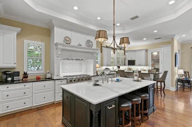 a kitchen with a stove a sink dishwasher a kitchen island with wooden cabinets and couches