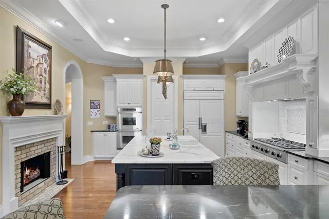 a large living room with stainless steel appliances kitchen island granite countertop furniture and fireplace