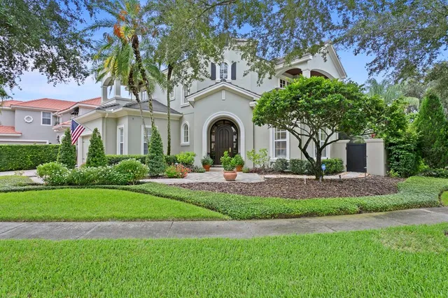 a front view of a house with a garden and trees