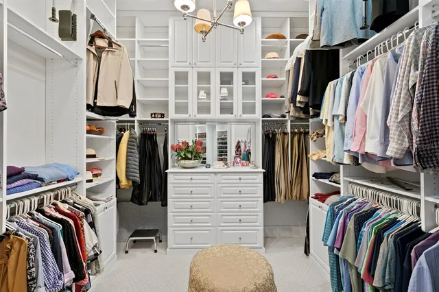 a view of walk in closet with clothes and shoes