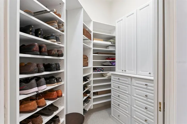 a view of walk in closet with clothes and shoes