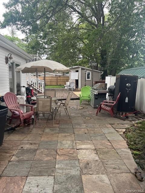 226 14th Avenue West Babylon, NY 11704 - Photo 24 of 27 a view of a patio with a table and chairs under an umbrella