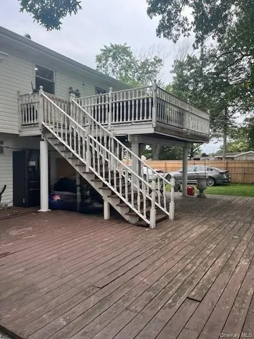 a view of a house with a deck and a yard