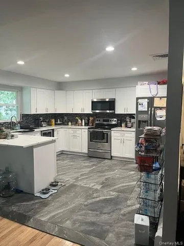 a kitchen with white cabinets and stainless steel appliances