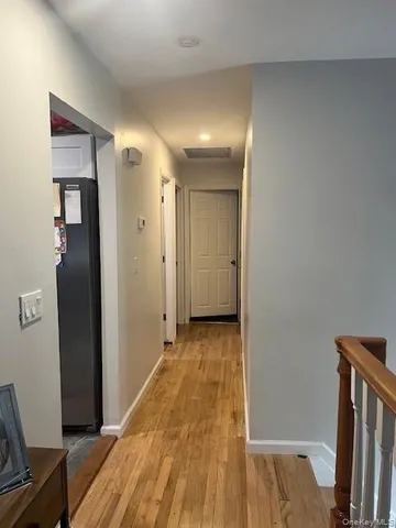 a view of a hallway with wooden floor and staircase