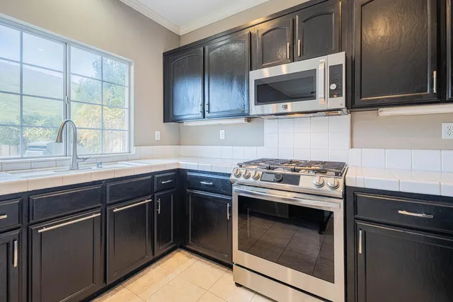 a kitchen with stainless steel appliances a stove microwave and sink