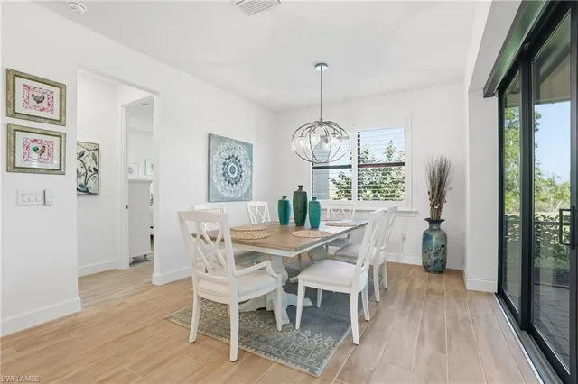 a view of a dining room with furniture a chandelier and wooden floor