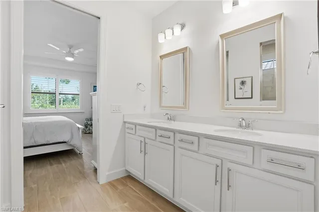 a en suite bathroom with 2 sink tub and a mirror