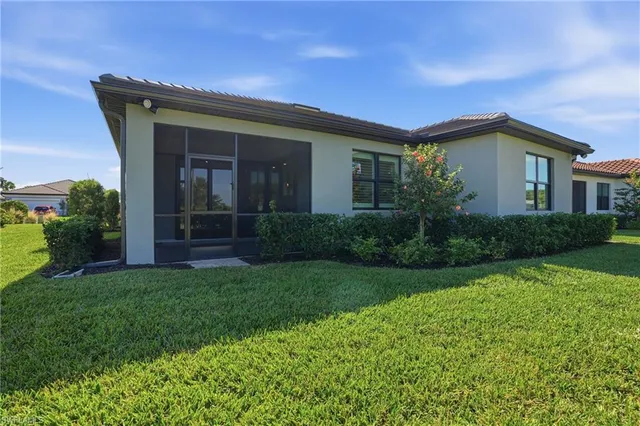 a front view of a house with a yard and potted plants