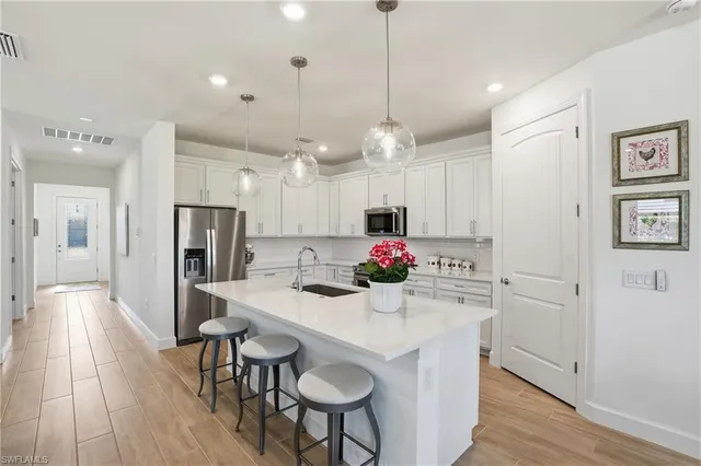 a kitchen with kitchen island a sink stove and refrigerator with wooden floor