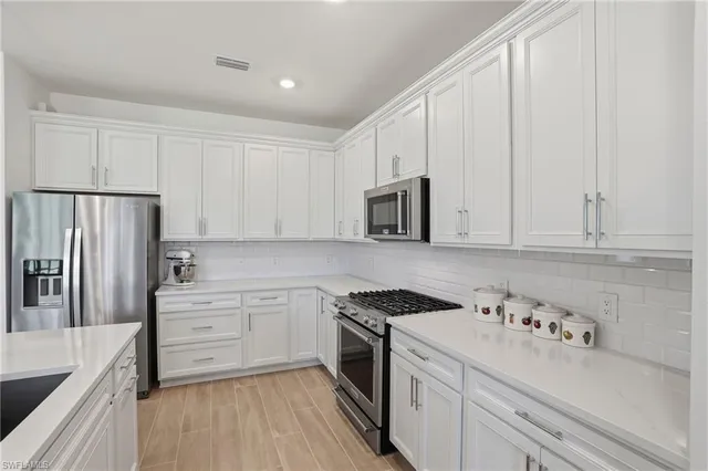 a kitchen with granite countertop white cabinets and white appliances