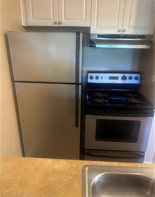 795 Hammond Drive, Unit 210 Atlanta, GA 30328 - Photo 17 of 18 a close view of a stove top oven and cabinets