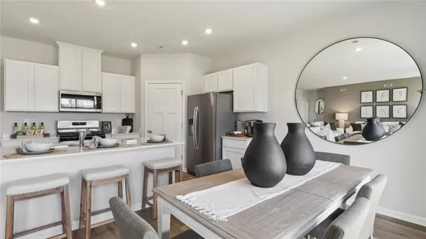 a kitchen with sink a refrigerator and chairs