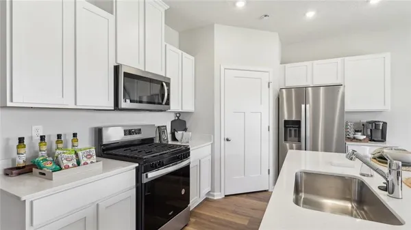 a kitchen with stainless steel appliances granite countertop a sink stove and refrigerator