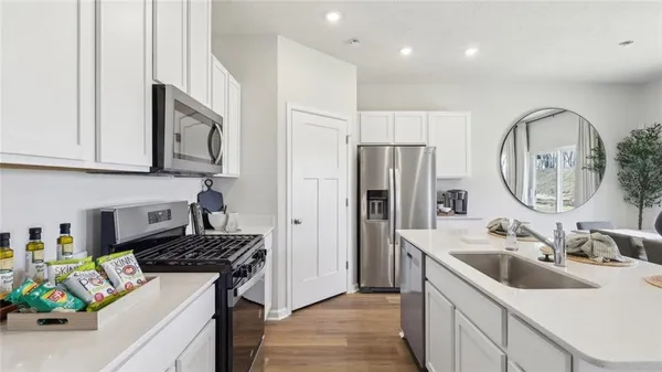 a kitchen that has a sink a refrigerator and a stove top oven