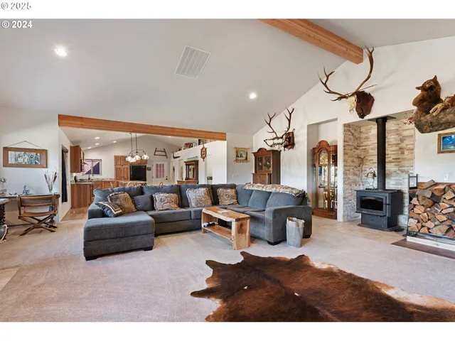 a living room with furniture a large window and a chandelier