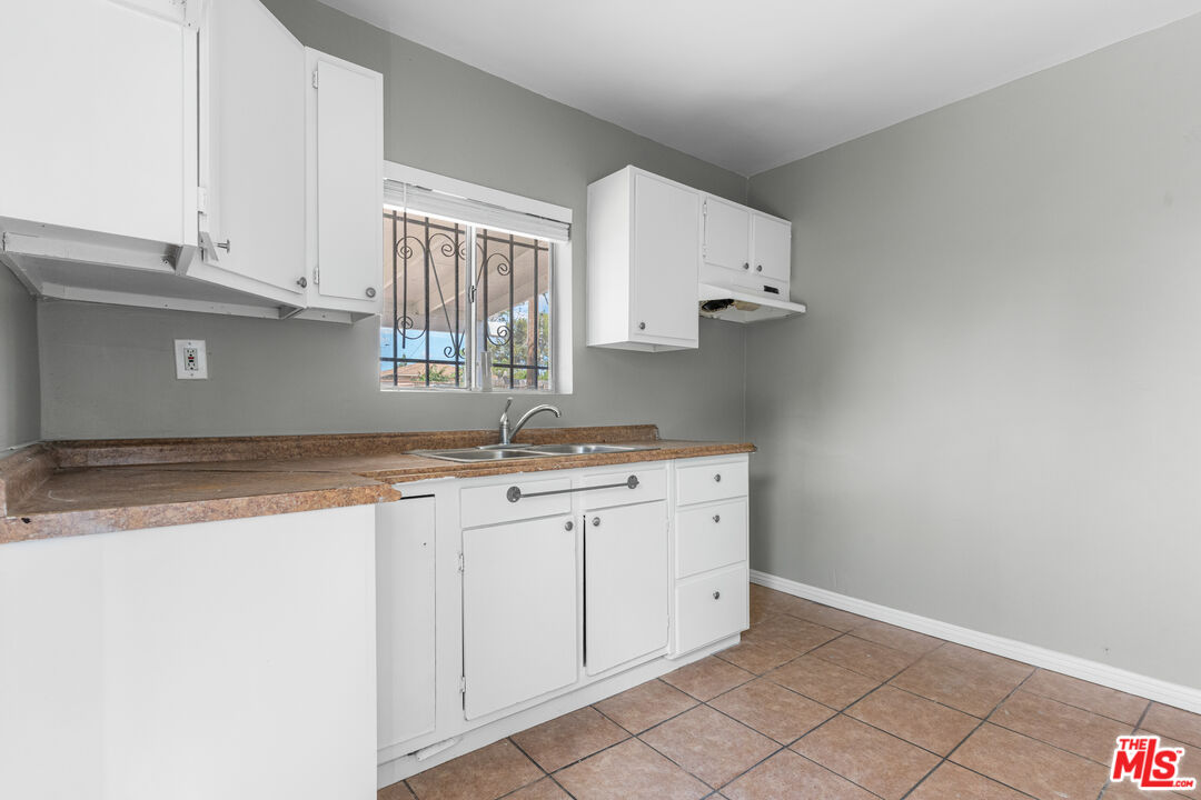 15321 South Frailey Avenue Compton, CA 90221 - Photo 7 of 19 a kitchen with granite countertop white cabinets white appliances and a sink