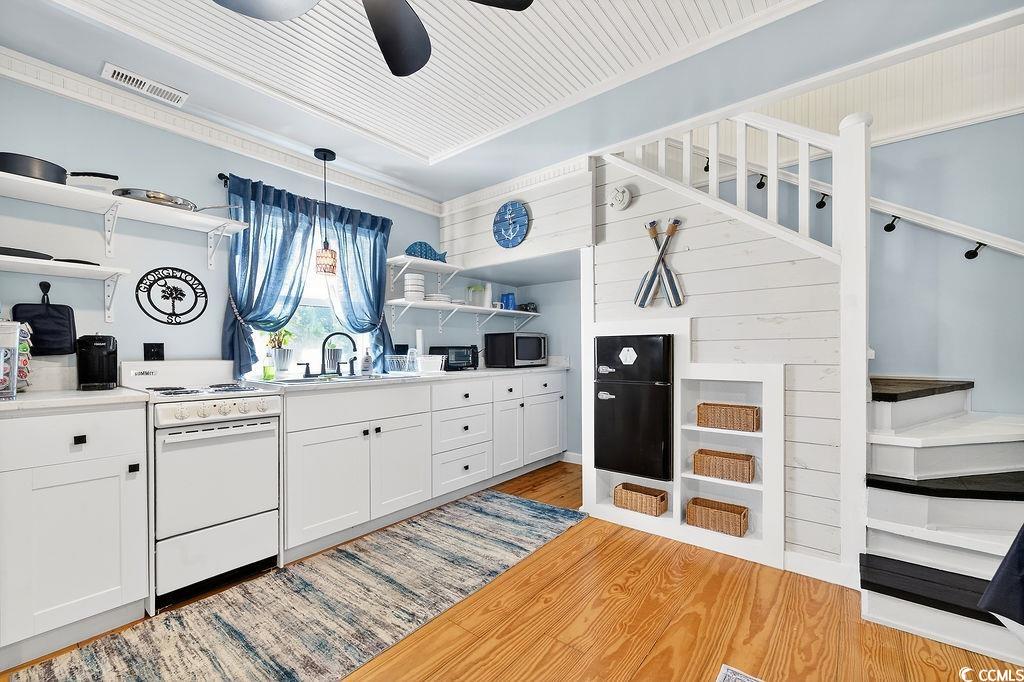 1137 Palmetto Street Georgetown, SC 29440 - Photo 24 of 40 Kitchen with open shelves, electric stove, white cabinets, light countertops, and light wood-type flooring