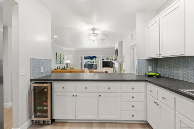 a kitchen with granite countertop white cabinets and a sink