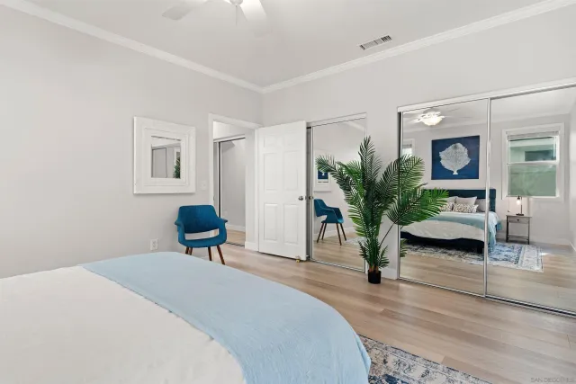 a bedroom with a bed a table and a potted plant