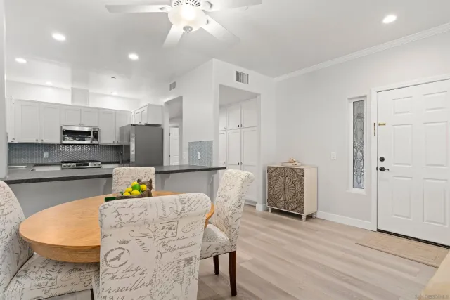a kitchen with stainless steel appliances granite countertop a white cabinets and chairs