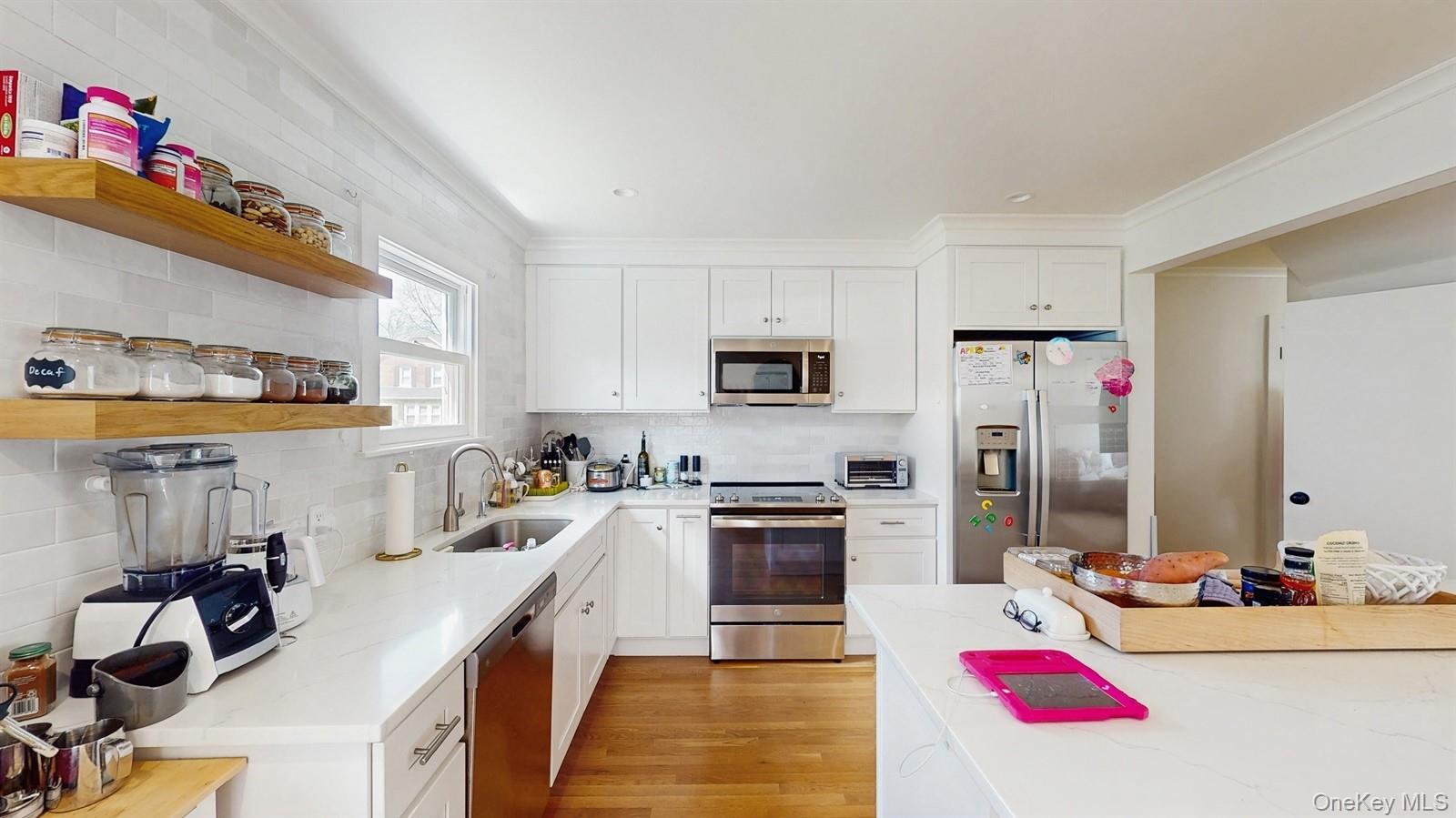 170 Wetherill Road Garden City, NY 11530 - Photo 9 of 23 Kitchen featuring tasteful backsplash, open shelves, a sink, stainless steel appliances, and light wood-style flooring