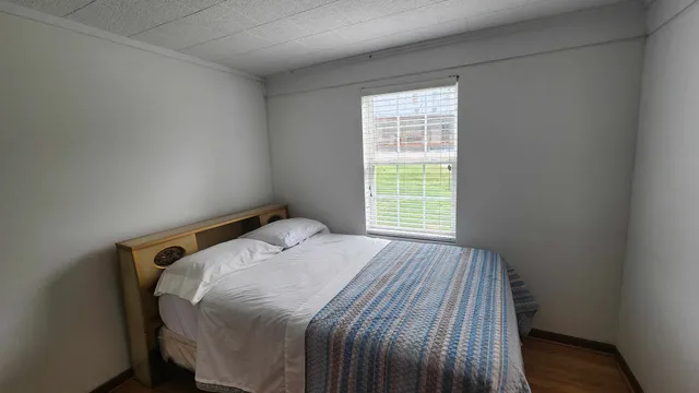 a bedroom with a bed and a window