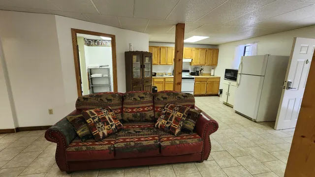 a living room with furniture windows and a refrigerator