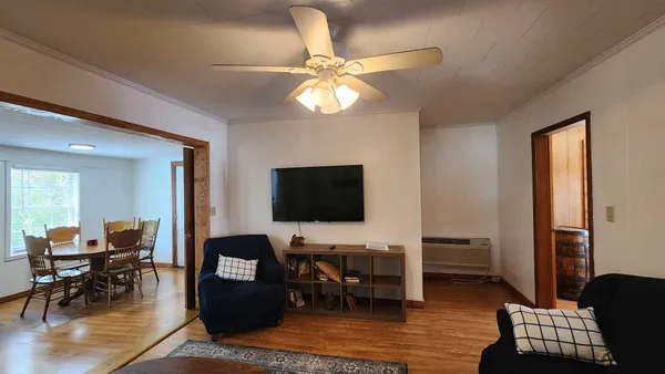 a living room with furniture a flat screen tv and a table