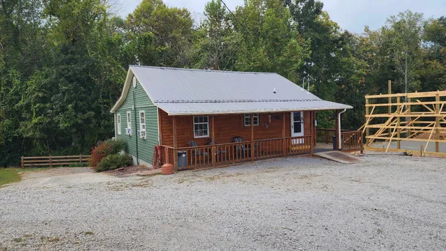 a view of a patio with couches table and chairs with wooden fence and plants