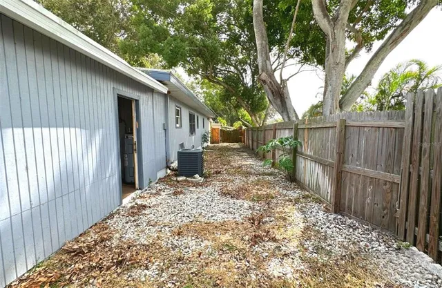 a view of a house with a small yard and a large tree