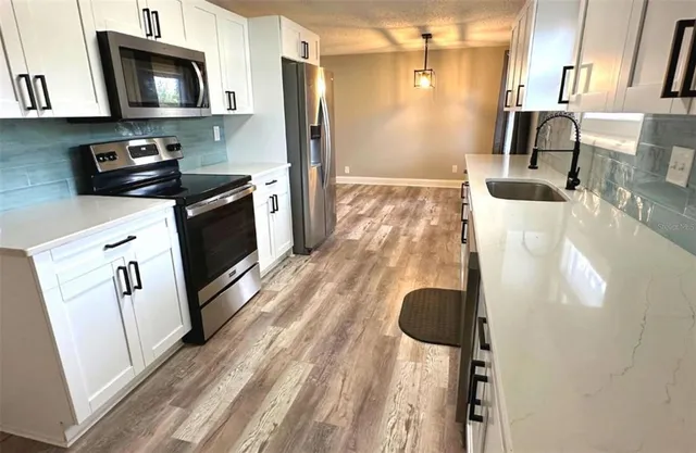 a kitchen with a refrigerator and a stove