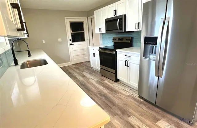 a bedroom with a bed flat screen tv and washer