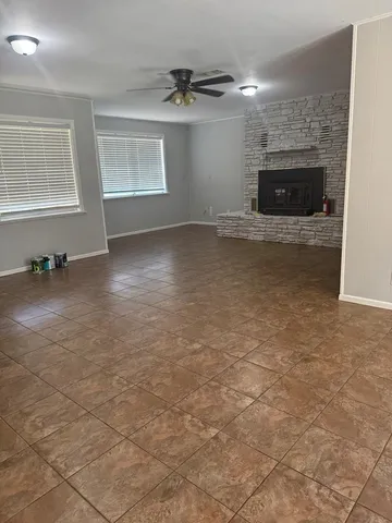 an empty room with windows and fireplace