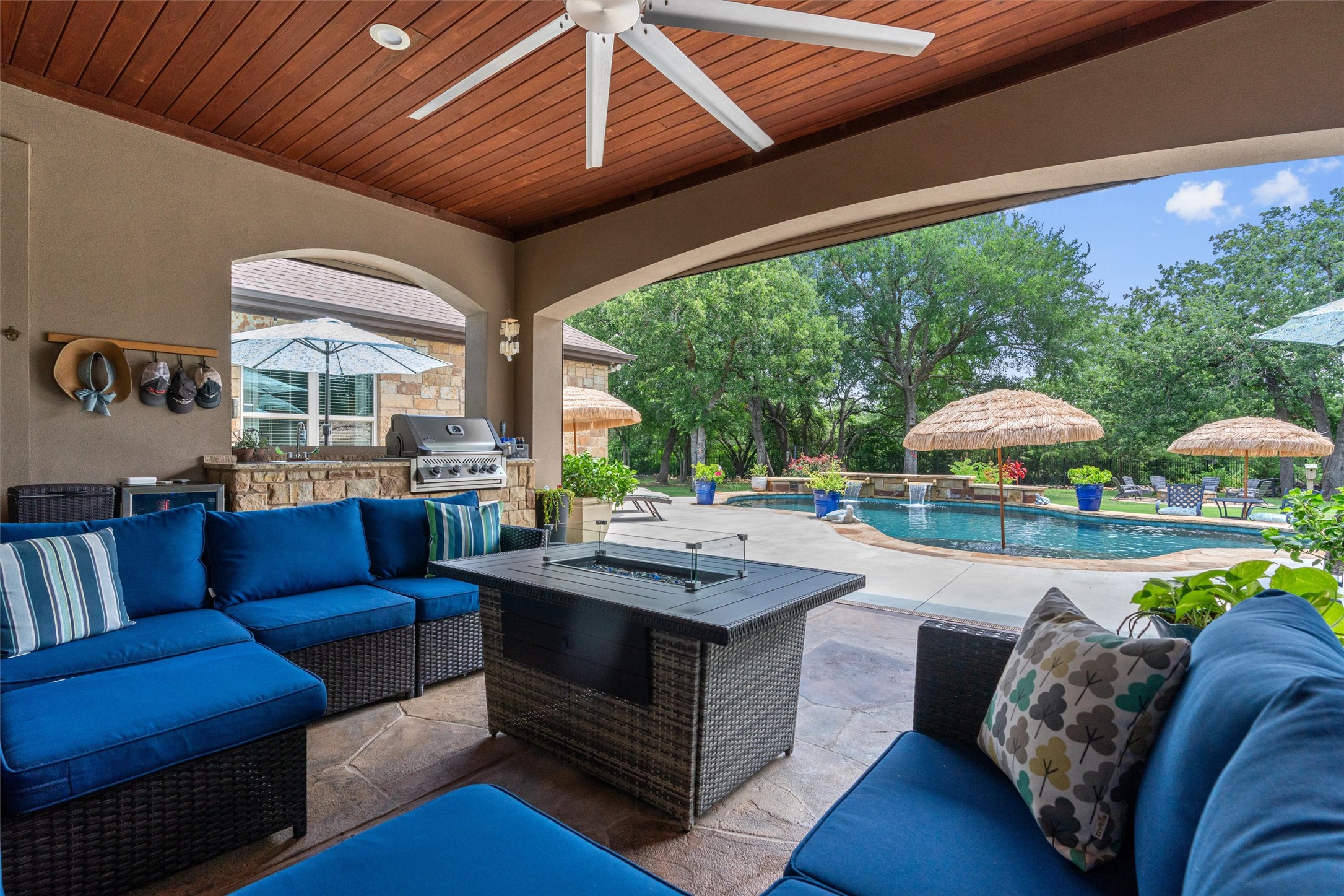 104 Adobe Cove Georgetown, TX 78633 - Photo 30 of 40 An inviting covered patio featuring a built-in outdoor kitchen, seating, and a refreshing pool with water features.