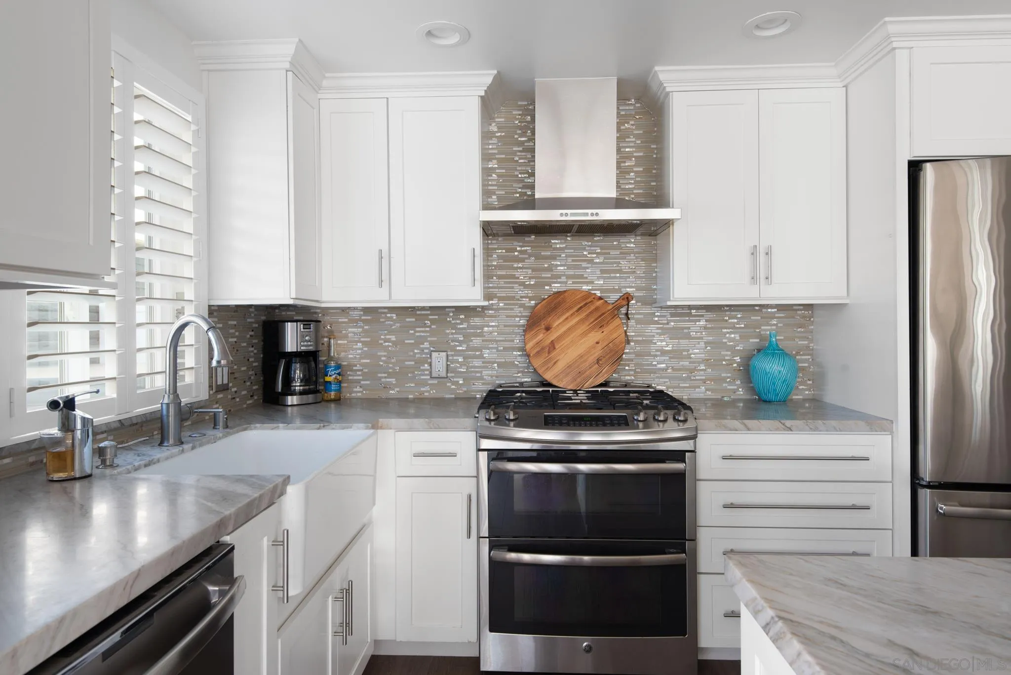 1933 Coast Boulevard Del Mar, CA 92014 - Photo 21 of 47 a kitchen with stainless steel appliances granite countertop a stove a refrigerator and a sink