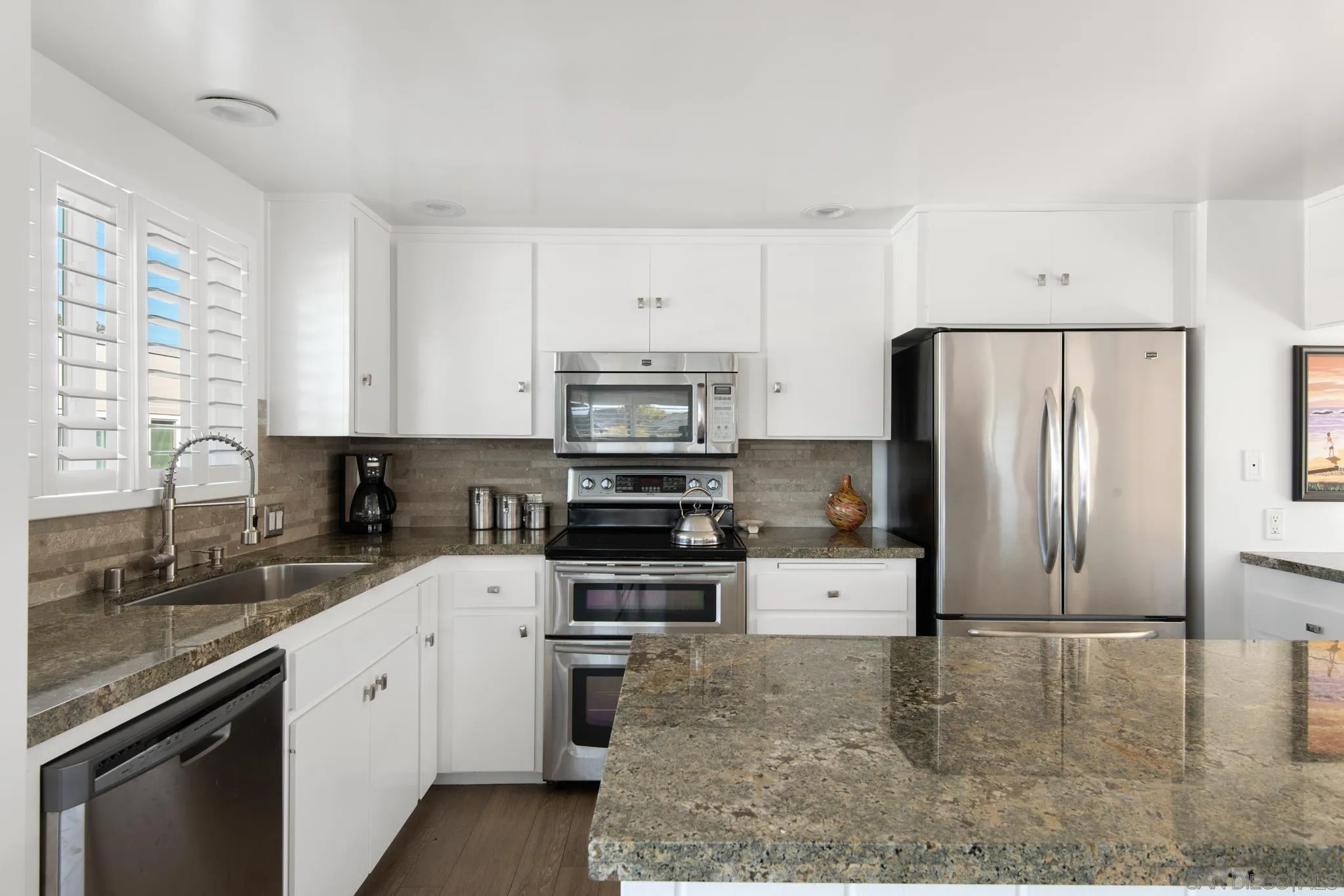 1933 Coast Boulevard Del Mar, CA 92014 - Photo 23 of 47 a kitchen with stainless steel appliances granite countertop a stove a sink and a refrigerator