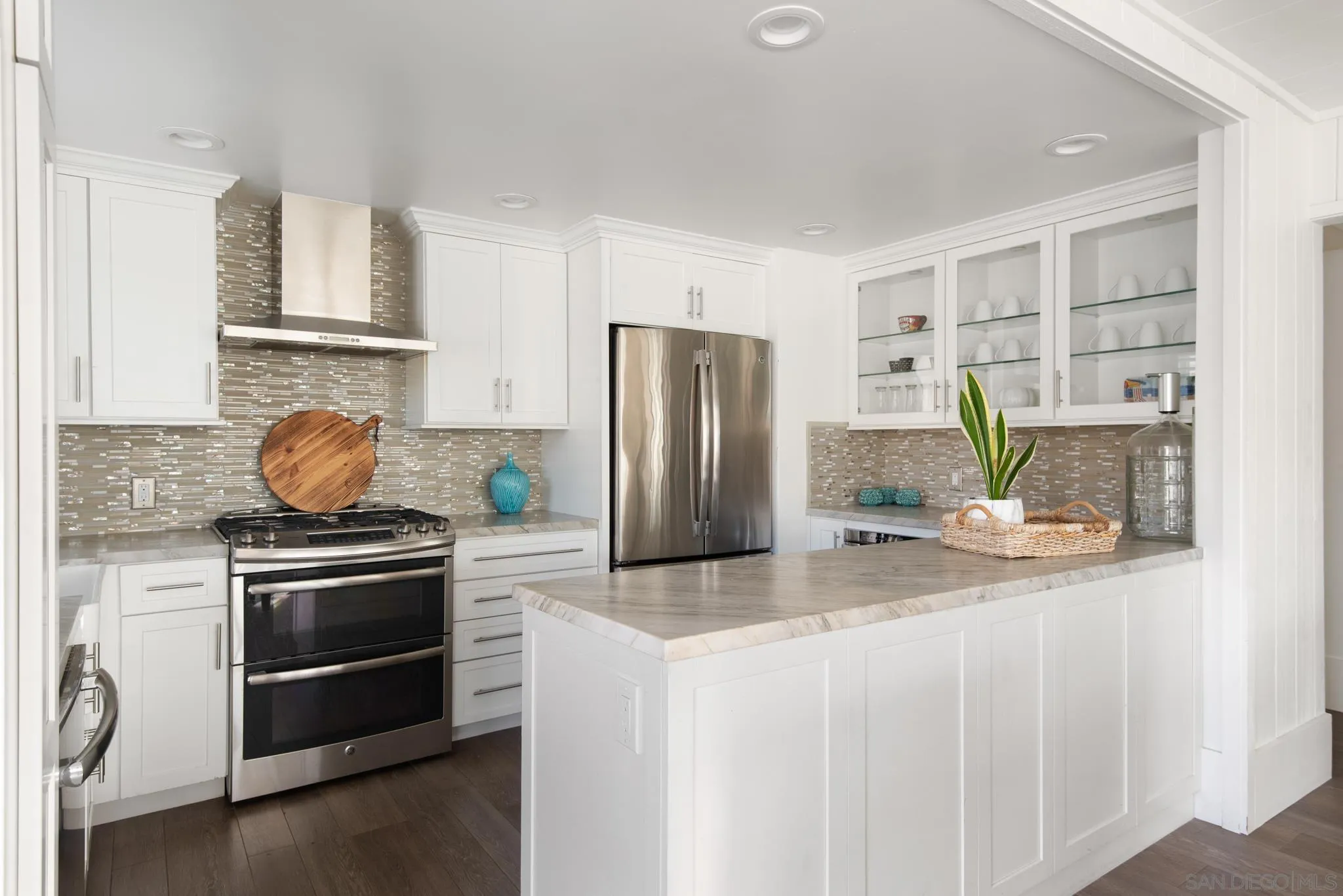 1933 Coast Boulevard Del Mar, CA 92014 - Photo 5 of 47 a kitchen with stainless steel appliances granite countertop a stove a refrigerator and a granite counter tops with white cabinets